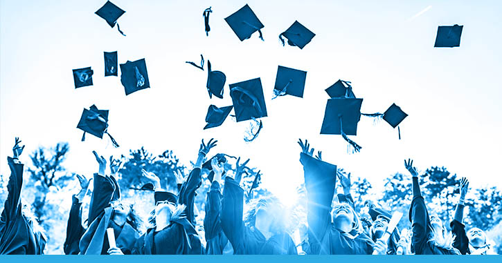 Students throwing graduation hats in the air