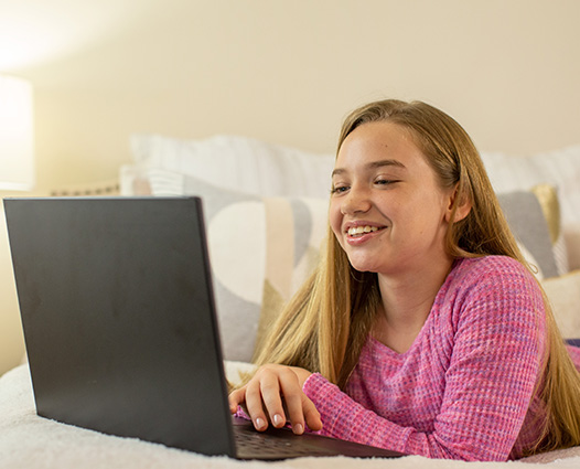 Student working on a laptop at home during a virtual class or online learning session.