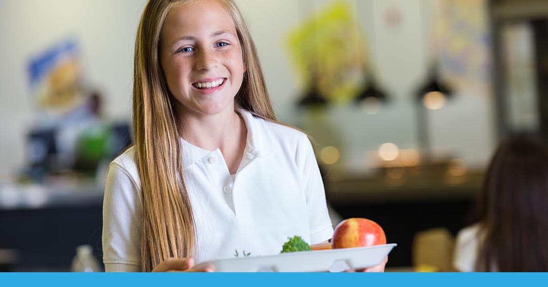 Student holds her lunch food tray while at school