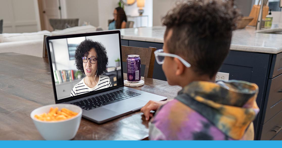 Child engaging in an online learning session with Florida Virtual School on a laptop, with a bowl of cheese puffs and a soda can nearby.