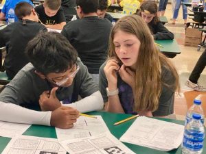 Bella works on math problems with her friend.