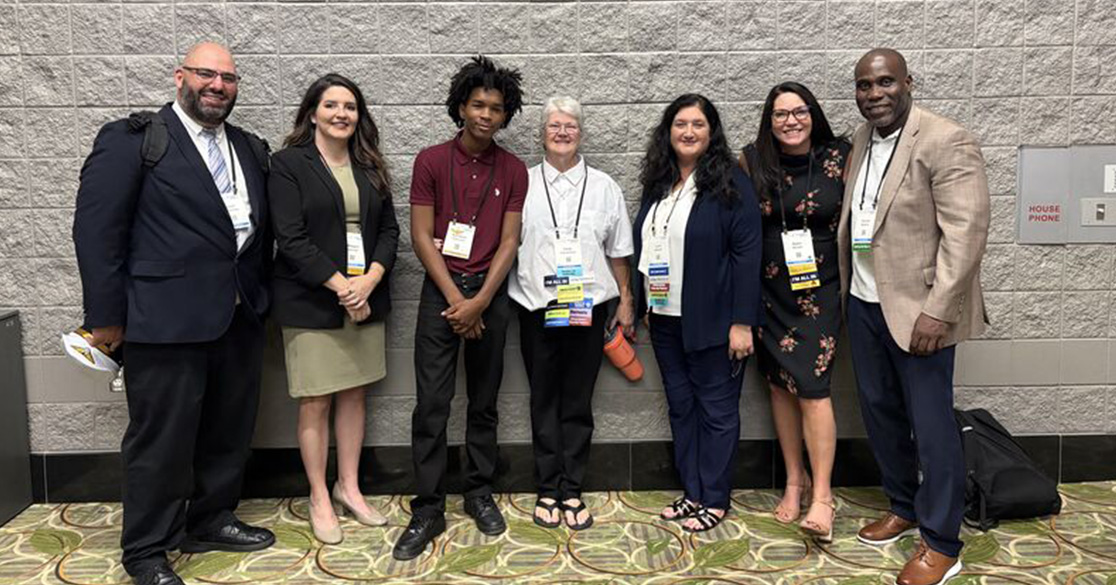 Florida Scholars Academy (FSA) graduate Kahliayah Robinson, center left, is pictured with educators and school leaders after sharing how perseverance and education helped him achieve career success.