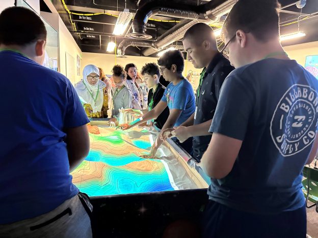 Students look at a projected map during STEM Camp