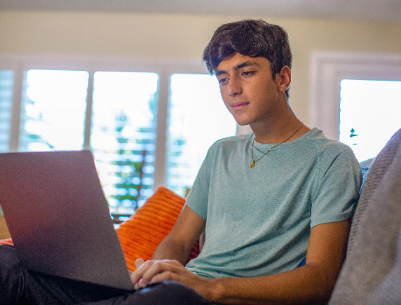 High school student independently working on his virtual coursework from home, demonstrating the flexibility of online learning.